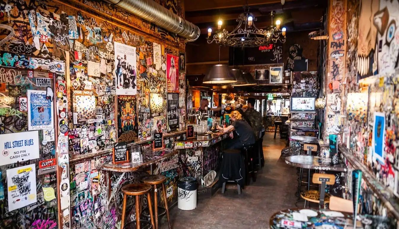 Hill Street Blues Coffeeshop Amsterdam – Iconic Graffiti-Covered Exterior by the Canal