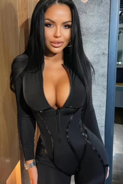 Sexy brunette escort Amsterdam wearing black outfit with zipper highlighting body shape and curves